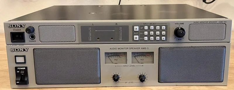 A Sony AMS-100 audio monitor speaker stacked on top of the much larger Sony AMS-3, both front panels facing out
