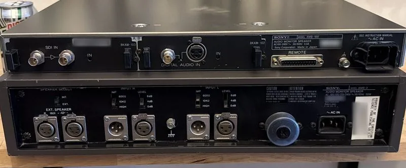 Rear panels of both units: the AMS-100 with SDI and digital audio inputs and option card slots, the AMS-3 with six XLR connectors and external speaker outputs