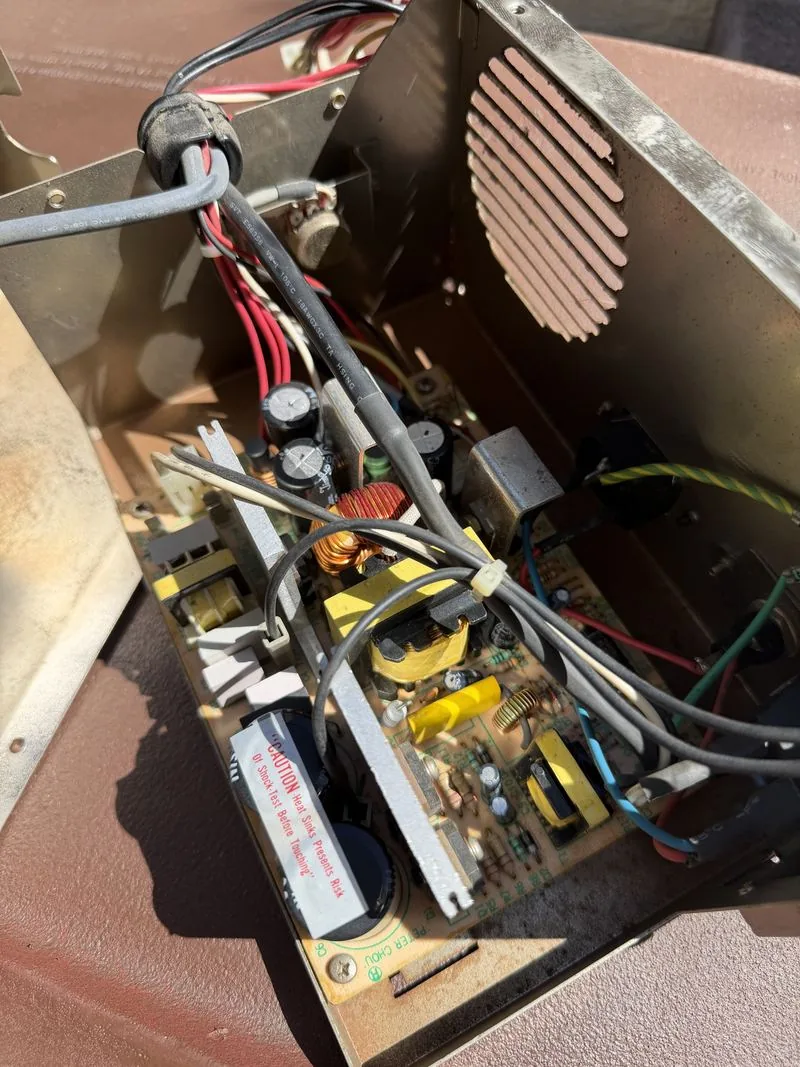 The same power supply after being blown out with compressed air, the circuit board and components now visible