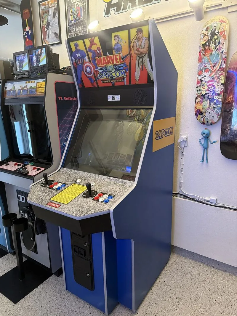 The Dynamo Big Blue seen from the front left, the yellow Capcom logo decal running down the side of the cabinet