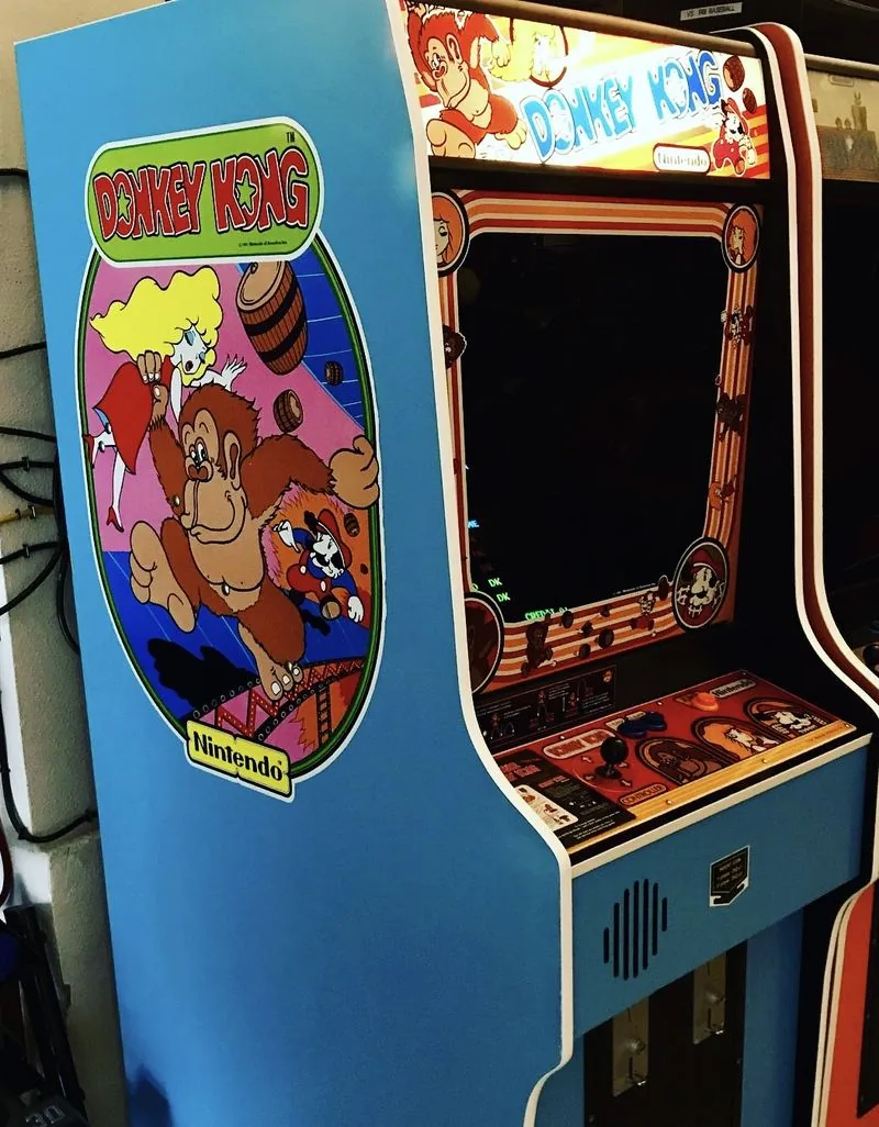 Close view of the Donkey Kong cabinet side art showing Donkey Kong, Pauline and Mario on the blue cabinet