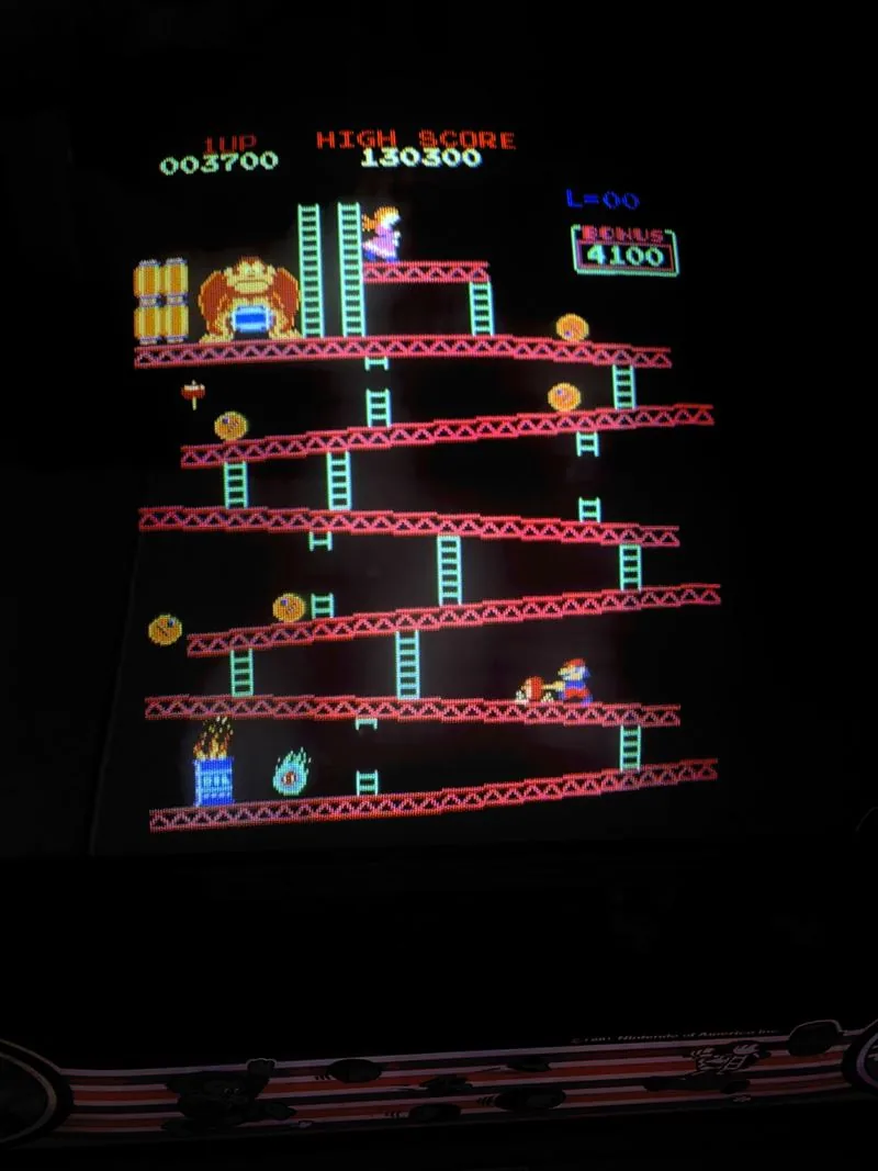 The Donkey Kong screen mid-game showing the girder stage, barrels rolling, score on the board