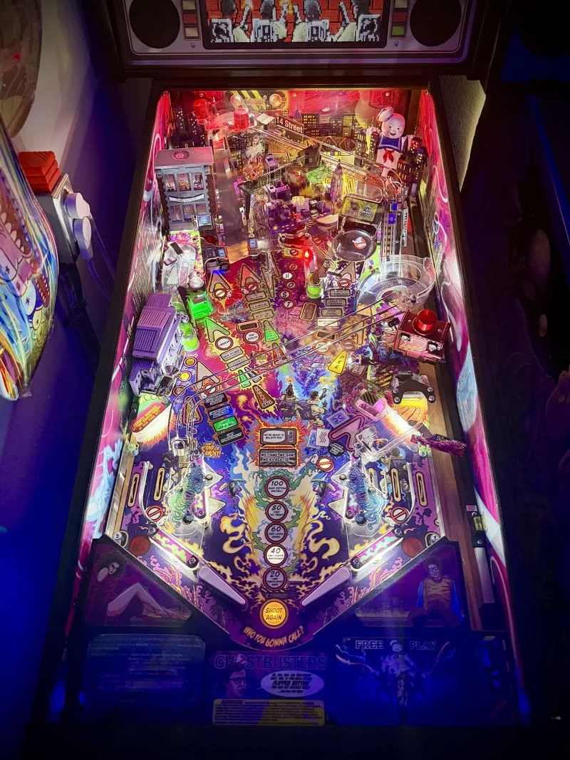 The Ghostbusters Premium playfield lit in pink and purple, showing the ramps and Zombie Yeti artwork