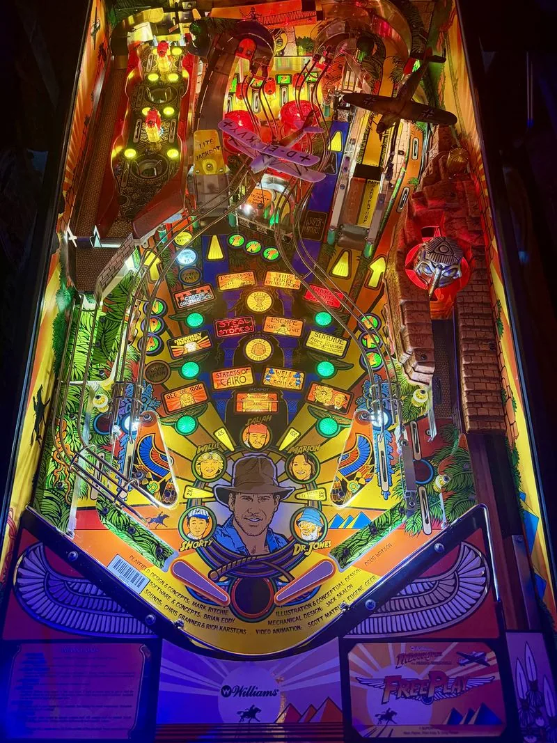 The Indiana Jones pinball playfield lit up, showing the ramps, mine cart and center idol