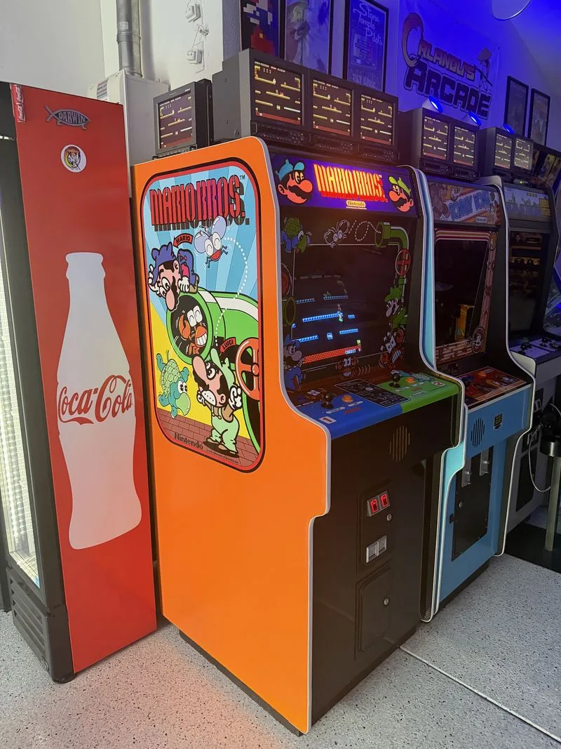 The Mario Bros. widebody cabinet beside the glass-bottle Coca-Cola cooler