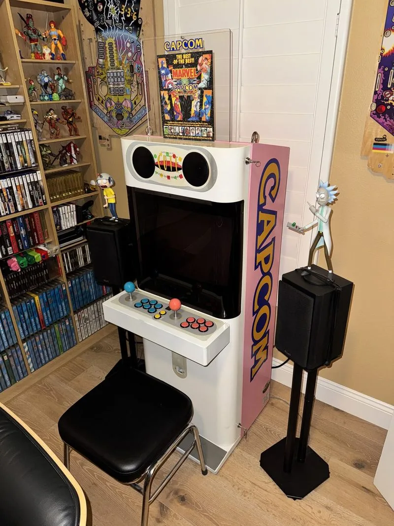 Pink Capcom Mini Cute candy cabinet beside shelves of games and figures