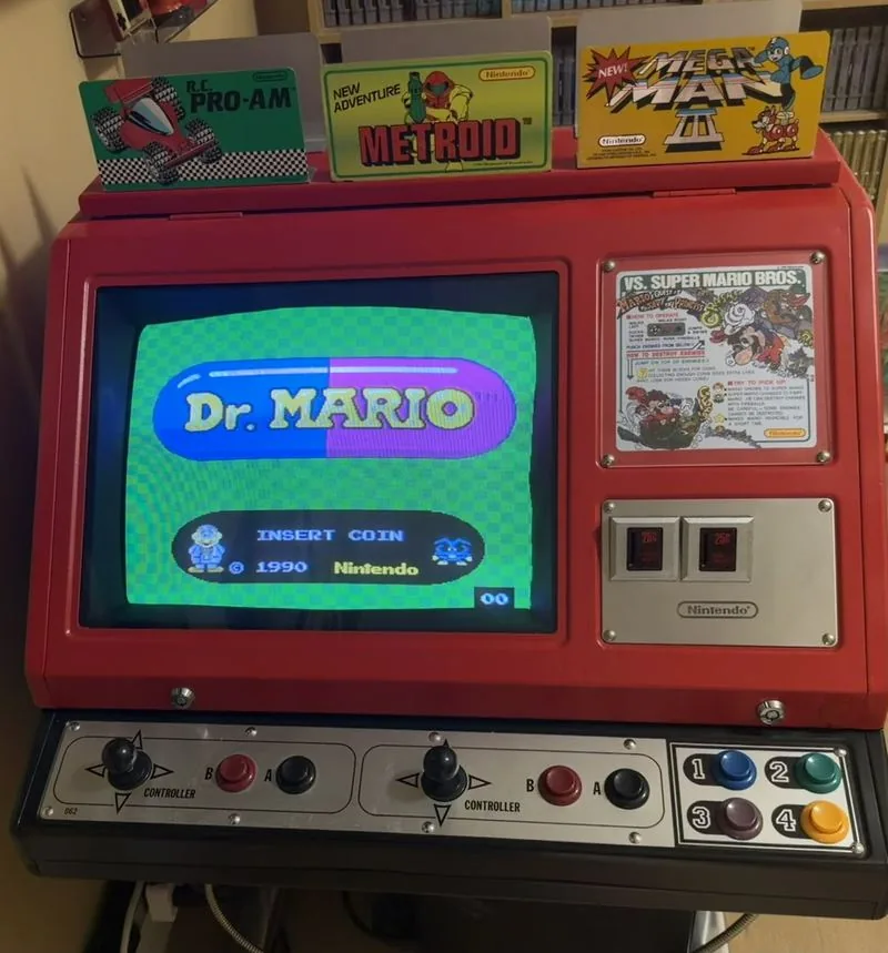 The restored Red Tent with Dr. Mario on screen, a VS. Super Mario Bros. instruction card beside it and three game toppers on the canopy