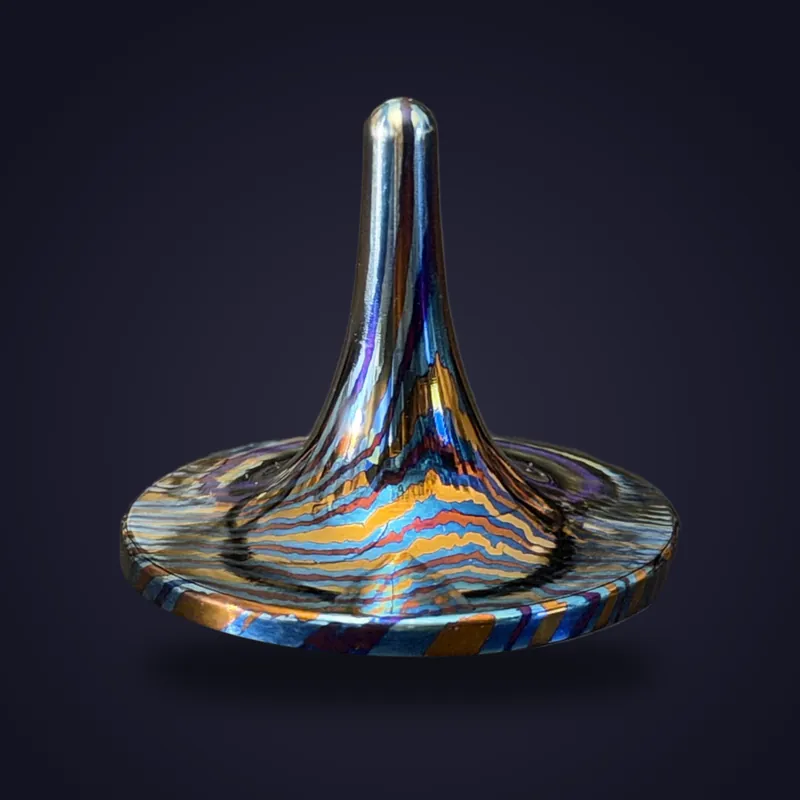 Foreverspin Mokume-Gane Titanium spinning top, photographed off its base